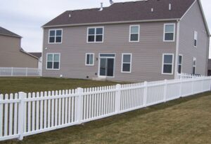 Big house with white wooden fence
