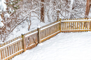 Wooden backyard fence of house with snow covered ground