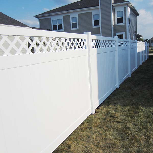A white fence with a decorative lattice panel on the side in Batavia, IL