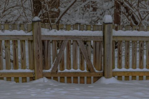 wooden fence covered in snow