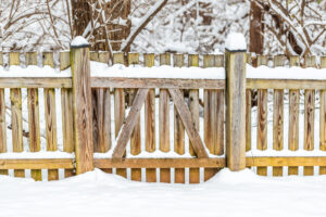 Wooden fence gate covered in white snow