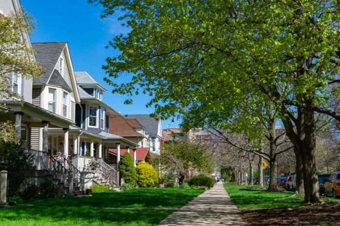 A row of old wooden homes with front lawns and a sidewalk in the North Center neighborhood of Chicago, IL