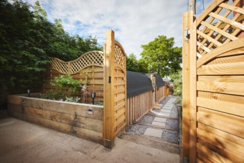 Backyard garden fence and walkway at home in summer, surrounded by trees and landscape in Chicagoland, IL