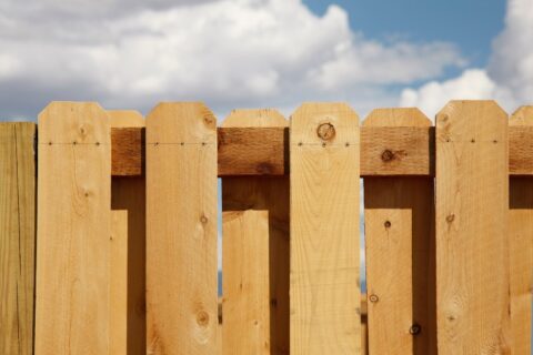 Cedar picket fence against blue sky in Chicago, IL