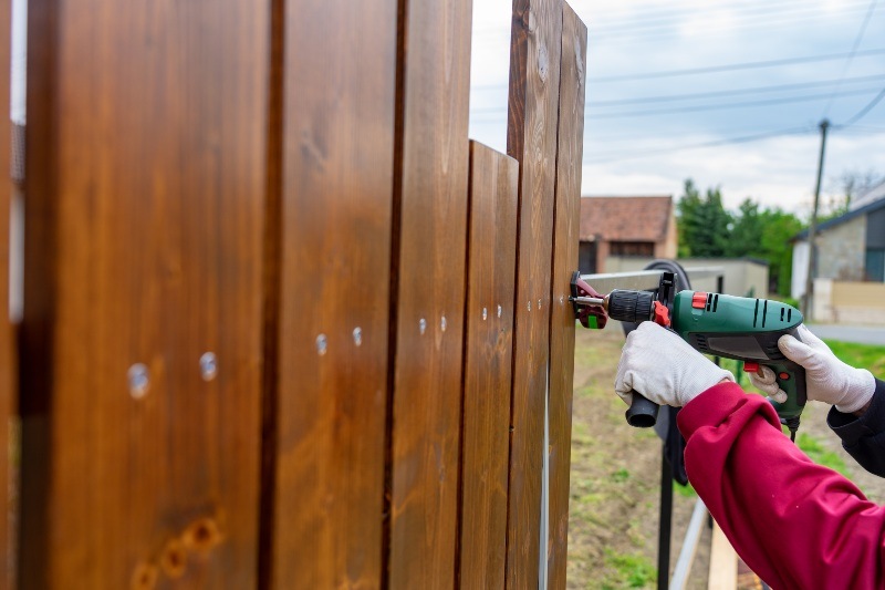 Installing wooden fence panels with drill and screws in Chicago, IL